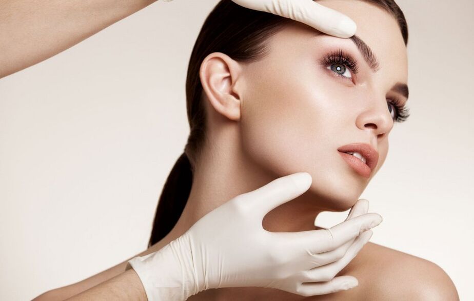 beautician examines facial skin before rejuvenation